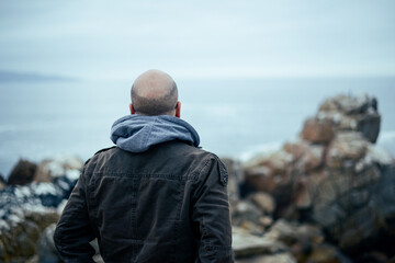 Back portrait of man watching the sea