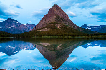 dramatic and beautiful  sunrise in Swift Current Lake in Many Glacier. The lake was perfectly still and created the reflections of Mt.Grinnell and Mt.Wilbur.