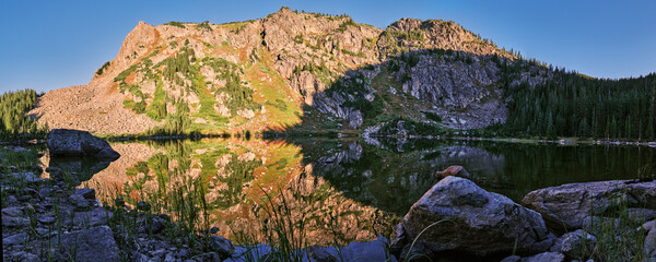 Panorama of mountain range over a lake at sunset.