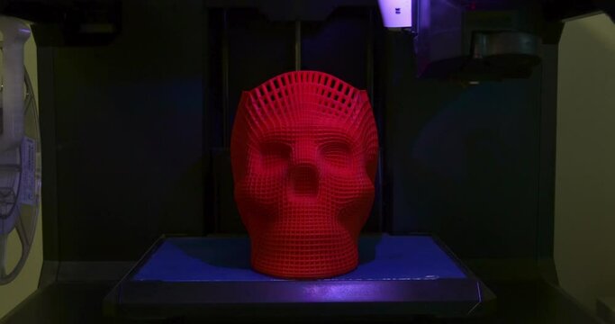 Skull printed with plastic of red color on a 3d printer.