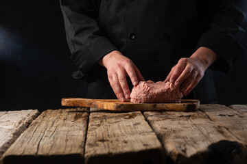 Chef prepares minced meat for cooking cutlet for burgers. Butcher shop, culinary recipes with space for banner or advertisement