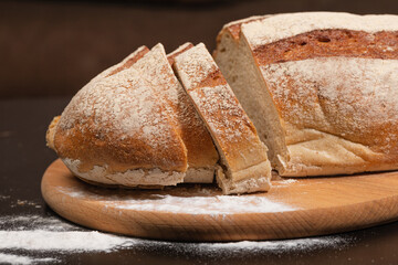 Fresh homemade baked goods. Freshly baked bread on a wooden board. Bread slices.