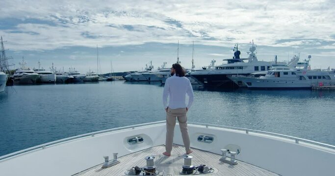Handsome man from behind standing on a boat sailing into the seagate - Cinematic scene with RED Camera 4K