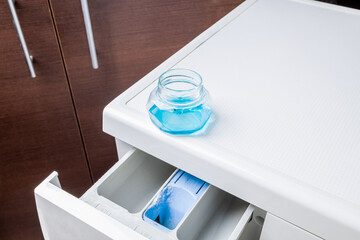 laundry using liquid detergent concept. detergent product cap on washing machine. hygiene housework conceptual