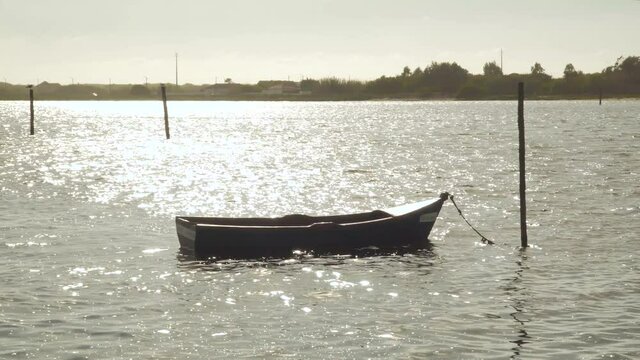 4K wooden boat moored in the Ria de Aveiro in the estuary of the river Vouga, boat balancing in the river current.