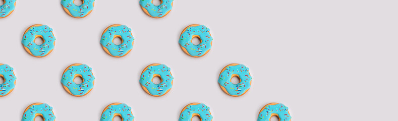 The creative pattern of colorful donuts on pastel blue background. Minimal food concept. Isometric.