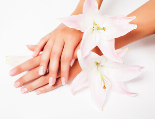 Obraz na płótnie Canvas manicure pedicure with flower lily closeup isolated on white perfect shape hands spa salon