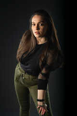 Portrait of beautiful model in black dress, hat and sunglasses on gray background