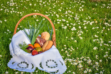 Easter food basket blessing, tradition in Eastern Europe, basket with easter eggs, ham, bread and sprind onion, priest blessing