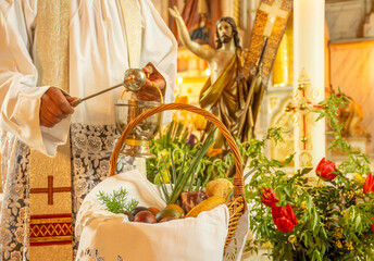 Easter food basket blessing, tradition in Eastern Europe, basket with easter eggs, ham, bread and sprind onion, priest blessing