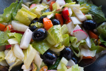 mixed green salad with big black olives