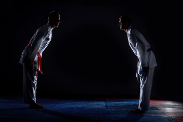 Male karate fighters in white kimono training