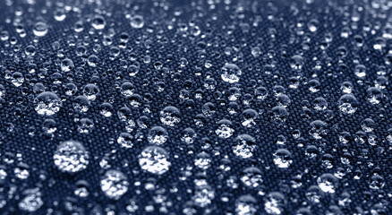 Many water drops on dark blue waterproof fabric