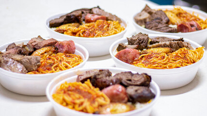 Marmitex with meat, pasta and rice in a white bowl - packed lunch - Brazilian Food.