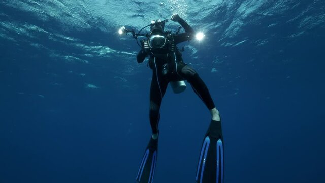 Slow Motion: Scuba Diver With Camera Swimming In Blue Ocean