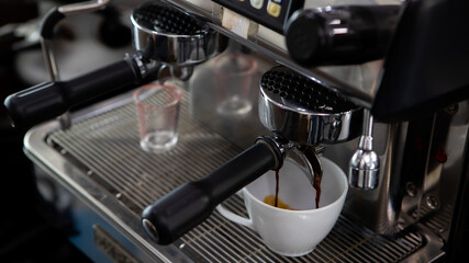 Close up photo of making coffee with machine in cafe. Professional modern espresso coffee machine pours hot drink into the cup. Concept coffee in cafe.