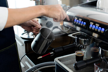 Close up hand holding Whipped cream with coffee. Making a cup of coffee in a coffee machine, the steam and the cup. Espresso maker machine with portafilter close up. Concept Coffee maker in cafe.