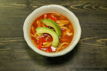 A bowl of chicken tortilla soup with crispy tortilla strips.