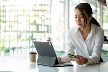 girl makes a purchase on the Internet on the smart tablet with credit card - online shopping concept.