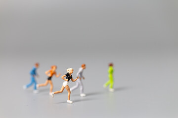 Miniature people Running on gray background and free space for text , Run for health concept