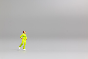 Miniature people Running on gray background and free space for text , Run for health concept