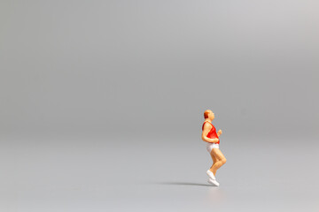 Fototapeta na wymiar Miniature people Running on gray background and free space for text , Run for health concept