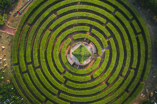 Aerial view of a circular garden maze and green pavilion