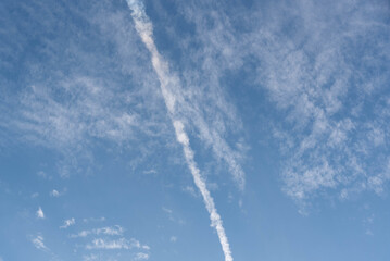 Fototapeta na wymiar Blue sky cut by smoke from airplane fuel