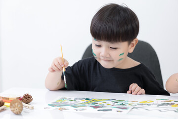 Happy little Asian kid at the table draw with water color Learning and education of kid.