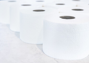 Pile of clean toilet paper white marble background. Everyday household lavatory object. Concept of hygiene and sanitary accessories. Depth of field