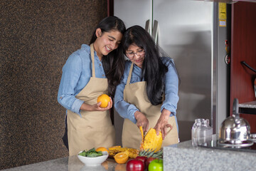 Madre e hija mexicanas cocinando en la cocina, el día de las madres