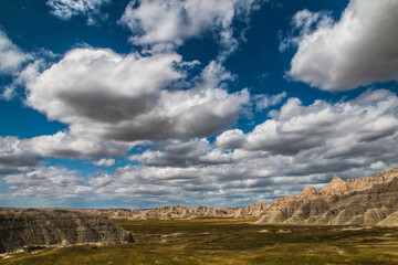 low cotton like summer clouds covering the sky in Badlands National Park in South Dakota.