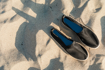 Black canvas espadrilles on the beach aerial view with design space