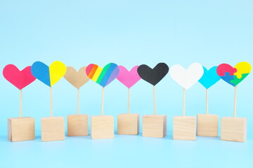 Cultural, racial, gender, age and general equality, inclusion, love and diversity concept. Multicolored heart shape icons in blue background.	