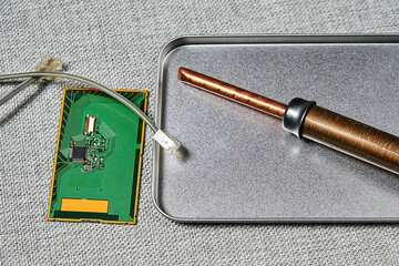 PCB with a microchip, connectors, wires, soldering iron in the manufacture. Microelectronics and...