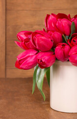 Fresh pink tulips on the wooden background.