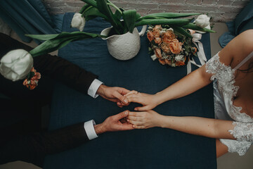 a man and a woman hold hands while sitting at a table, without faces