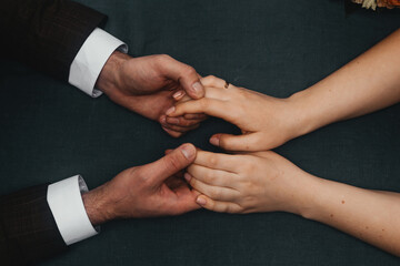 a man and a woman hold hands while sitting at a table