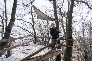 8 year old caucasian boy rejoices at his new toy house built on trees