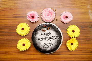 Decorative chocolate cake for 25th anniversary on wooden table