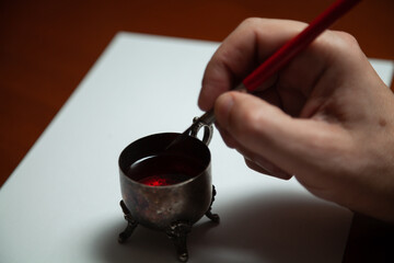 Hand dips fountain pen in inkwell