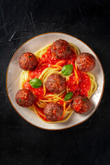 Meatballs with spaghetti, shot from above on a dark background