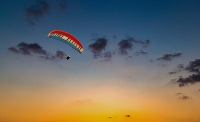 Paraglider flying in the beautiful sky against the background of clouds.