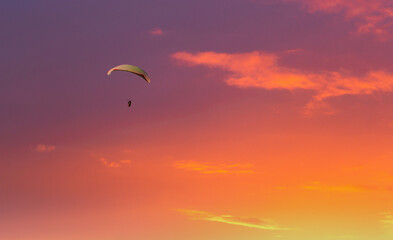 Paraglider flying in the beautiful sky against the background of clouds.