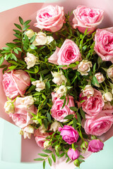 Mother's day, womens day or birthday greetings concept. Beautiful bouquet of blooming delicate pink roses and spring greenery on a green background.