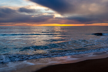 Fototapeta na wymiar View of a sunset over a sea.