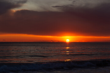 Naklejka na ściany i meble View of a sunset over a sea.