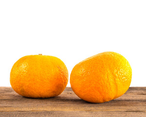 Two oranges on a wooden surface on a white background
