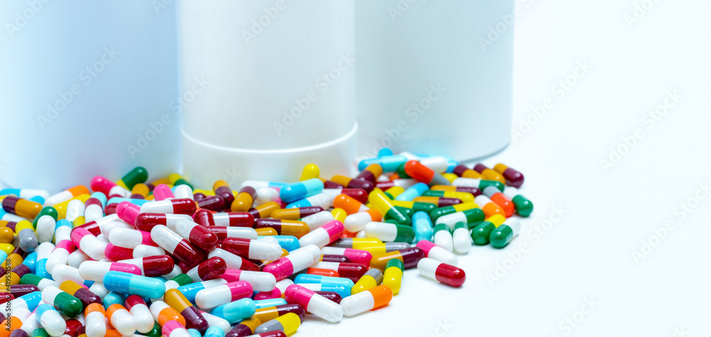 Poster pile of colorful antibiotic capsule pills on blurred plastic drug bottles. antibiotic drug resistanc