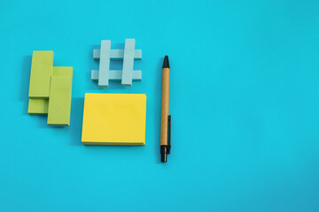 Stickers of different sizes and colors are placed on a blue background. There's a pen next to it.